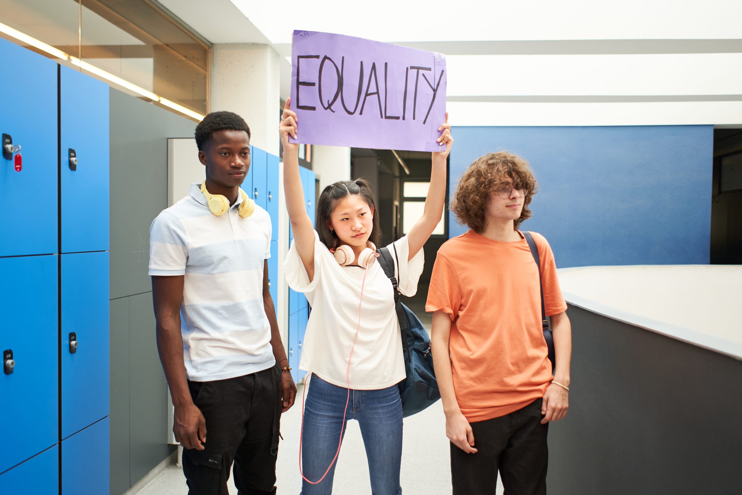 Group of students carrying a banner at school protesting for equality.